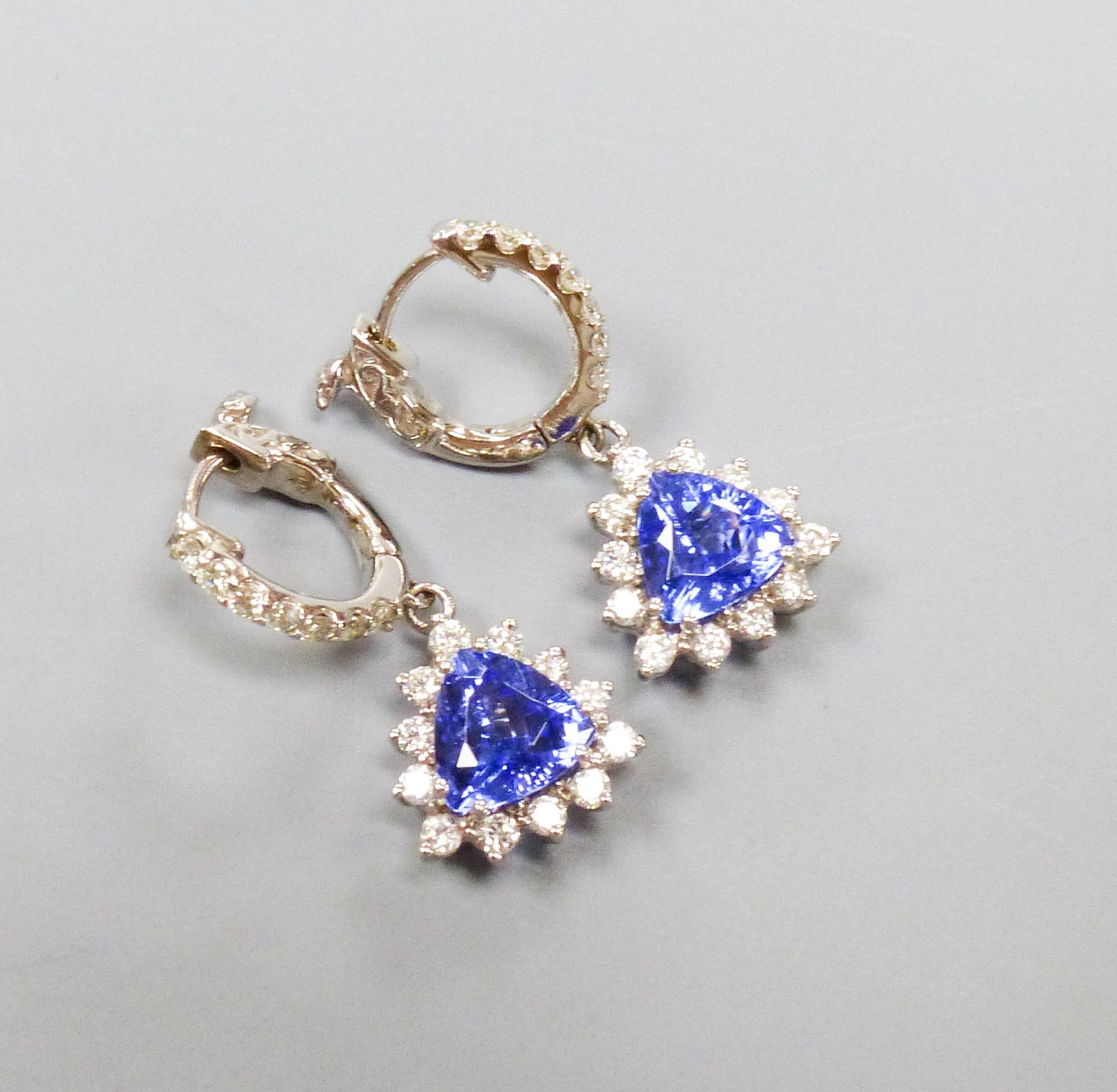 A modern pair of 14k white metal trillion cut tanzanite and diamond chip set cluster drop earrings, overall 26mm, gross weight 5.9 grams